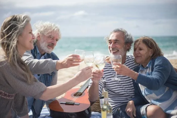 viajes-para-gente-sola-mayor-de-50-personas-brindando-en-playa